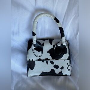 Cow print mini bag with one handle. Worn with love!